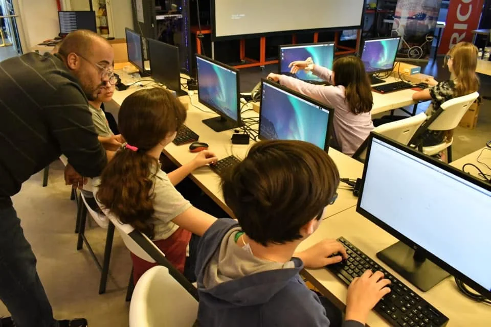 An instructor helping students during a hands-on computer workshop.